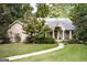 Traditional brick home featuring a well-maintained lawn and mature trees, creating an inviting entrance at 2275 Honeysuckle Se Ln, Smyrna, GA 30080