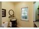 Charming powder room featuring a round mirror, pedestal sink, and a window with natural light at 2275 Honeysuckle Se Ln, Smyrna, GA 30080