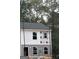 New construction home with gray and white siding and black roof surrounded by green trees at 7264 Crestside Dr # 66, Austell, GA 30168