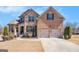 Charming two-story home with a brick and stone facade, a two-car garage, and landscaped front yard at 124 Shelton Dr, Mcdonough, GA 30252