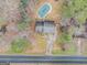 Aerial view of cozy home featuring a private pool, driveway, and mature landscaping at 620 Bell Se Rd, Conyers, GA 30094