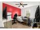 Bedroom with a ceiling fan, grey walls, red accent wall, window and carpet flooring at 620 Bell Se Rd, Conyers, GA 30094