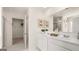Modern bathroom featuring double sinks, white marble countertops, and access to a walk-in closet at 615 Edgar St # 13, Hampton, GA 30228