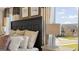 Bright bedroom highlighting a large headboard, decorative pillows, and a serene view from the windows at 615 Edgar St # 13, Hampton, GA 30228