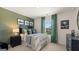 Stylish bedroom features a green accent wall, modern décor and window with natural light at 615 Edgar St # 13, Hampton, GA 30228