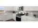 Modern kitchen features stainless steel appliances, white cabinets, and sleek gray backsplash at 615 Edgar St # 13, Hampton, GA 30228