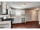 Modern kitchen with white cabinets, stainless steel appliances, and hardwood floors, great for cooking and entertaining at 6746 Lake Erie Ln, Fairburn, GA 30213