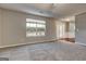 Bright living room featuring large window, neutral carpeting, and an open layout, perfect for relaxation and entertaining at 6746 Lake Erie Ln, Fairburn, GA 30213