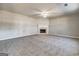 Inviting living room features a cozy fireplace, ceiling fan, and plush carpeting at 6746 Lake Erie Ln, Fairburn, GA 30213