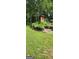 Spacious backyard featuring a grassy area surrounded by mature trees and foliage at 2317 Hillside Rd, Riverdale, GA 30296
