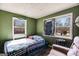 View of green-walled bedroom with two windows, bed, chair, and side table at 2864 S 100 Hwy, Bowdon, GA 30108