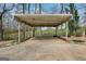 Open carport with a concrete pad, surrounded by grass and trees at 2864 S 100 Hwy, Bowdon, GA 30108