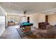 Spacious room with billiards table, fan, and a glimpse of the dining area and hallway at 2864 S 100 Hwy, Bowdon, GA 30108