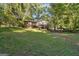 Spacious, tree-lined backyard with a raised deck on the home's exterior at 6226 Lullwater Dr, Douglasville, GA 30135
