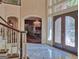 Grand foyer with marble floors, staircase, and double doors leading to formal dining room with chandelier at 101 Glen Eagle Way, Mcdonough, GA 30253