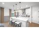 A modern kitchen with a white quartz island, counter seating, stainless steel appliances, and lots of natural light at 5711 Tillman Way, Powder Springs, GA 30127