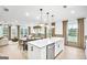 A bright kitchen featuring white cabinets, stainless steel appliances, a large island and an open view to the living area at 5711 Tillman Way, Powder Springs, GA 30127