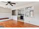 Open-concept living space with hardwood floors, a brick accent wall, and views into the well-lit, white kitchen at 3600 Old Stilesboro Nw Rd, Kennesaw, GA 30152