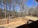 Inviting backyard deck with wooden railing overlooking a lush, wooded landscape and blue skies at 2395 Peeksville Rd, Locust Grove, GA 30248