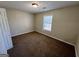 This cozy bedroom features neutral walls, a window with natural light, and plush carpeting at 2395 Peeksville Rd, Locust Grove, GA 30248