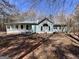 Light blue single-story home with a charming front porch, windows with black shutters, and mature trees at 2395 Peeksville Rd, Locust Grove, GA 30248