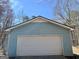 Exterior view of a single-car garage with a white door and light-blue siding, offering convenient parking at 2395 Peeksville Rd, Locust Grove, GA 30248