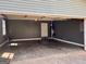 Open garage with concrete flooring, dark-grey walls, and a back door, ready for vehicles and storage at 2395 Peeksville Rd, Locust Grove, GA 30248