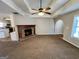Bright and airy living room with a brick fireplace, carpet flooring, and trey ceiling at 2395 Peeksville Rd, Locust Grove, GA 30248