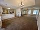 View of an open floor plan integrating living, dining, and kitchen areas under a tray ceiling with unique lighting at 2395 Peeksville Rd, Locust Grove, GA 30248