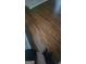 Close-up of the brown hardwood flooring in the residence, with a glimpse of shoes at 505 City Park Dr, Mcdonough, GA 30252