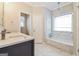 Elegant bathroom featuring double sinks, marble tile, and a tub with marble backsplash at 1116 5Th Nw St, Atlanta, GA 30318