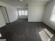 Sunlit bedroom with gray carpet, crisp white walls, and a large window with venetian blinds at 607 Tramore Ct, Stockbridge, GA 30281