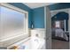 Sunlit soaking tub with tile surround and frosted window in primary bath at 4205 Lindsey Way, Conyers, GA 30013