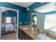 Elegant bathroom boasts a double sink vanity, granite countertops, and blue accent walls at 4205 Lindsey Way, Conyers, GA 30013