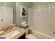 Bathroom featuring a granite vanity, mirror, toilet, shower with tub, light green walls and a zen inspired art piece at 4205 Lindsey Way, Conyers, GA 30013