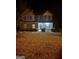 Charming two-story home with stone accents and well-lit landscaped front yard at nighttime at 4205 Lindsey Way, Conyers, GA 30013