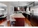Modern kitchen with a large island, stainless steel appliances, and dark wood cabinets, seamlessly flowing into the dining area at 4205 Lindsey Way, Conyers, GA 30013