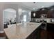 Stylish kitchen featuring a granite-topped island, stainless steel appliances, dark wood cabinetry, and elegant pendant lighting at 4205 Lindsey Way, Conyers, GA 30013