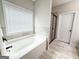 This bathroom features a soaking tub with tile surround and separate glass enclosed shower at 9178 Lakeview Pkwy, Villa Rica, GA 30180