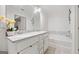 Bright bathroom featuring a double sink vanity, soaking tub, and decorative floral arrangement at 2271 Rolling Trl, Lithonia, GA 30058