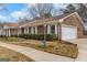 Charming brick home featuring a two-car garage, manicured bushes, and a well-kept lawn at 210 Heritage Cir, Mcdonough, GA 30253
