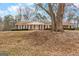 Classic brick home with white trim, a lush front lawn, and a mature tree in the yard at 210 Heritage Cir, Mcdonough, GA 30253