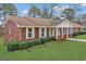 Charming brick home with manicured lawn, white trim windows and inviting columned front porch at 210 Heritage Cir, Mcdonough, GA 30253