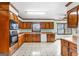 Traditional kitchen features wood cabinets, white appliances, and a patterned tile floor at 210 Heritage Cir, Mcdonough, GA 30253