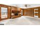 Cozy living room with brick fireplace, wood paneling, and a ceiling fan at 210 Heritage Cir, Mcdonough, GA 30253