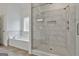 Modern bathroom featuring a glass-enclosed shower with marble surround and a soaking tub at 6025 Old Timber Trl # 11, Douglasville, GA 30135
