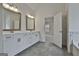 Large bathroom with dual vanities, gray tiled flooring and a view into the bedroom at 6025 Old Timber Trl # 11, Douglasville, GA 30135