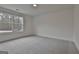 Empty bedroom featuring neutral carpet, a window providing natural light and white walls at 6025 Old Timber Trl # 11, Douglasville, GA 30135