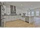 Spacious kitchen with stainless steel appliances, a farm sink, a stylish range hood, and white cabinets at 6025 Old Timber Trl # 11, Douglasville, GA 30135