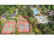 Aerial view showcases community amenities: pool, splash pad, tennis courts, parking, and a clubhouse amidst lush green landscaping at 6142 Golf View Xing, Locust Grove, GA 30248